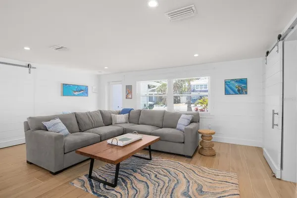 a living room with furniture and a wooden floor