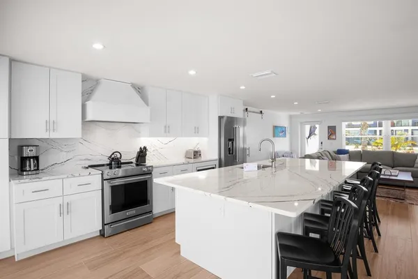 a large kitchen with sink a stove and chairs
