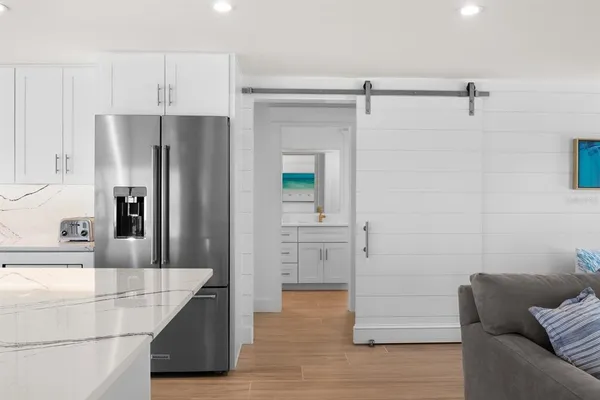 a kitchen with granite countertop a refrigerator and a sink