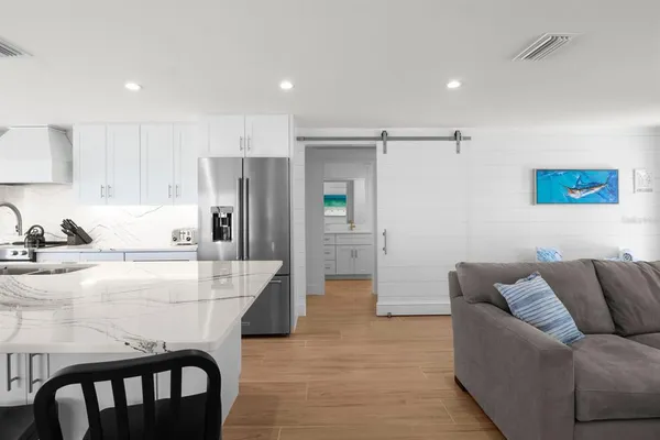 a living room with furniture and a refrigerator