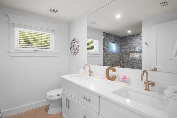 a bathroom with a sink toilet and a mirror