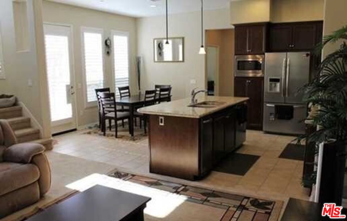20329 Paseo Los Arcos Porter Ranch, CA 91326 - Photo 2 of 22 a living room with stainless steel appliances kitchen island granite countertop a table chairs and a refrigerator