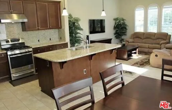 a living room with furniture a potted plant and a large window