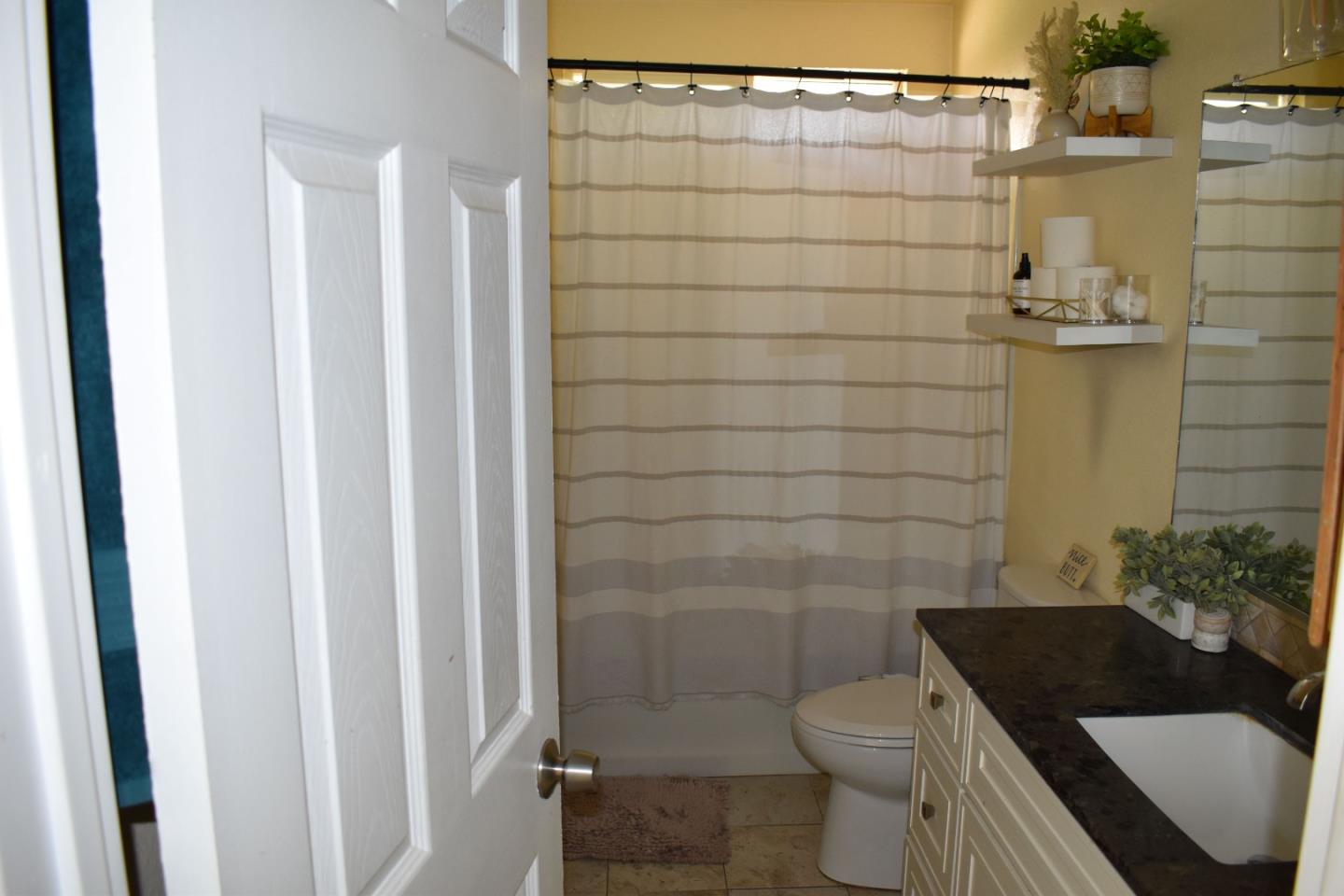 359 North 3rd Street Grover Beach, CA 93433 - Photo 12 of 23 a bathroom with a granite countertop toilet and a shower