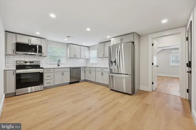 a kitchen with stainless steel appliances a refrigerator and a stove top oven