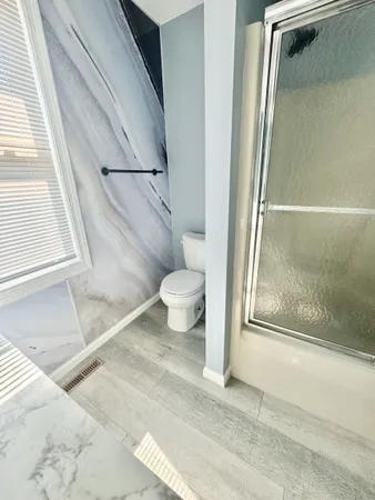 a bathroom with a toilet and a shower