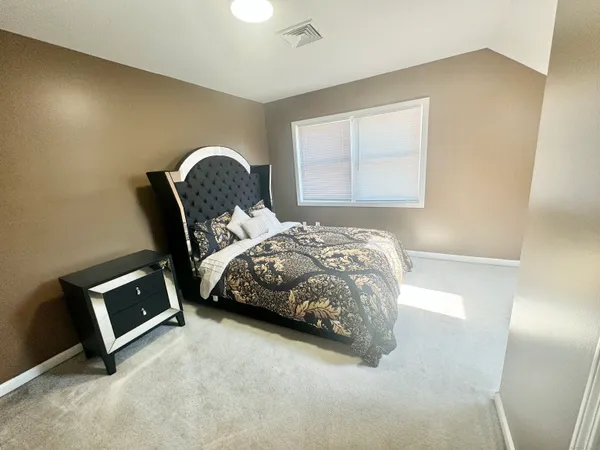 a bedroom with a bed a mirror and a window