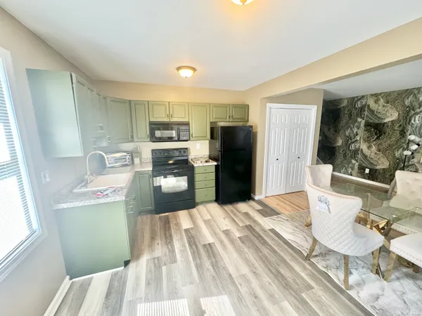 a kitchen with a refrigerator and a stove top oven