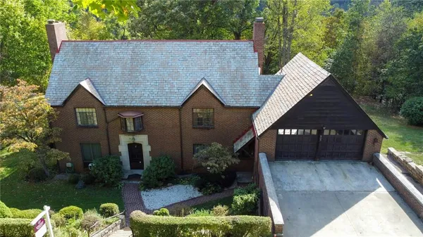 a view of a house with brick walls and a yard with plants
