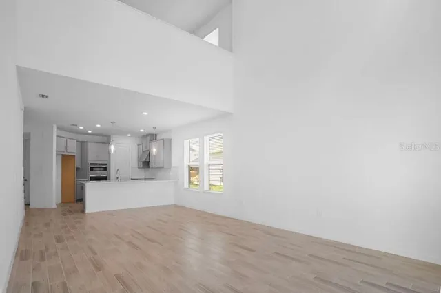 a view of an empty room with a kitchen