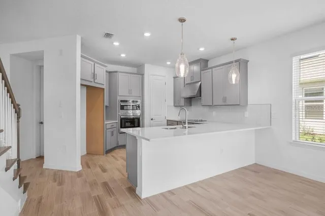 a large white kitchen with a large window