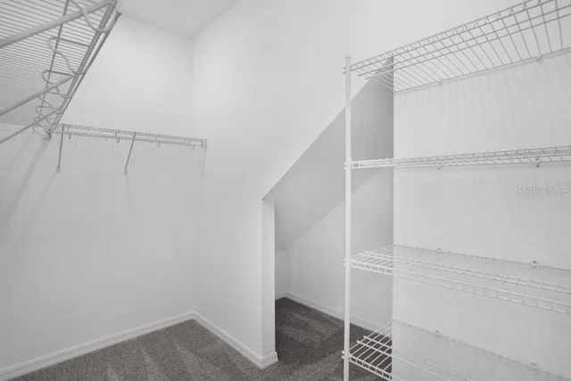 a view of walk in closet with empty racks