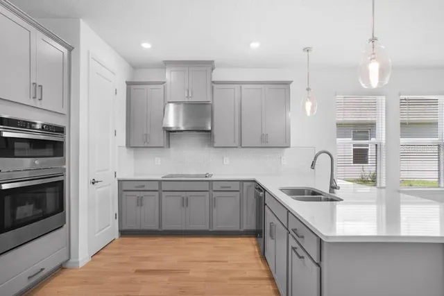 a kitchen with stainless steel appliances granite countertop a sink a stove and a refrigerator