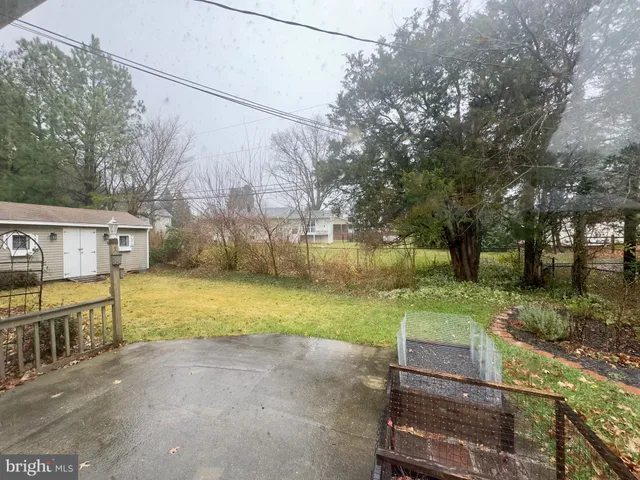 a view of a house with backyard and trees