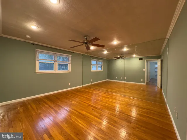 a view of empty room with wooden floor