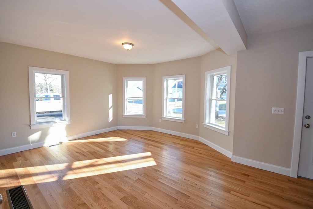 286 Wheeler Road Dracut, MA 01826 - Photo 14 of 32 a view of an empty room with wooden floor and a window