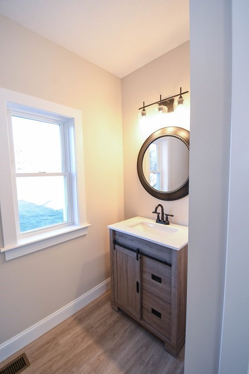 286 Wheeler Road Dracut, MA 01826 - Photo 27 of 32 a bathroom with a toilet a sink and a mirror
