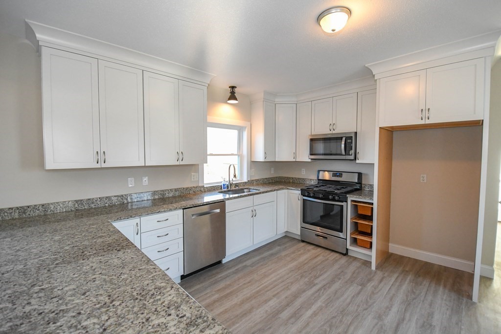286 Wheeler Road Dracut, MA 01826 - Photo 10 of 32 a kitchen with granite countertop white cabinets and stainless steel appliances