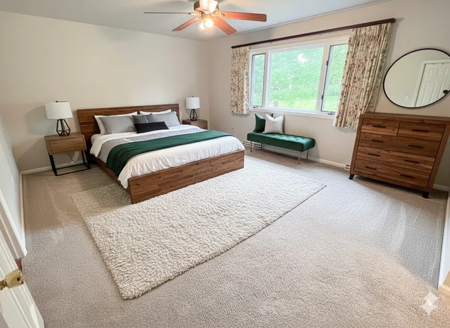 a bedroom with a bed a couch and large window