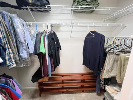 a view of walk in closet with clothes and shoes