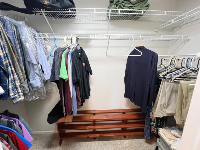 a view of walk in closet with clothes and shoes