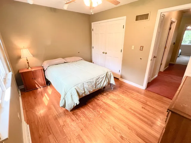 a bedroom with a bed and a wooden floor