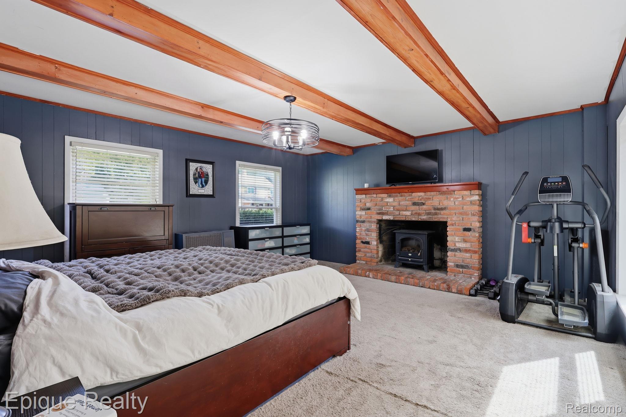 7441 Honeysuckle Road West Bloomfield, MI 48324 - Photo 19 of 35 Bedroom with wood walls, carpet floors, beamed ceiling and fireplace