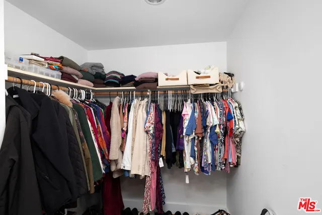 a view of walk in closet with clothes