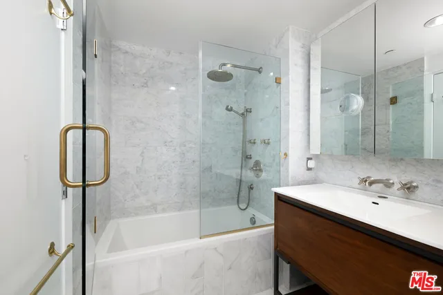 a bathroom with a bathtub shower sink vanity and toilet