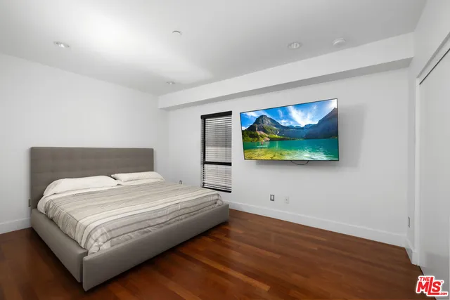 a bedroom with a bed and painting on the wall