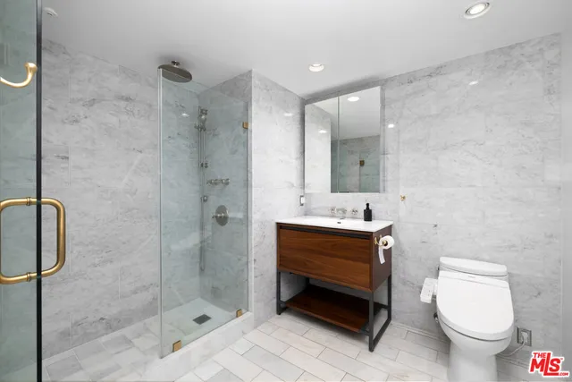 a bathroom with a sink toilet a mirror and shower