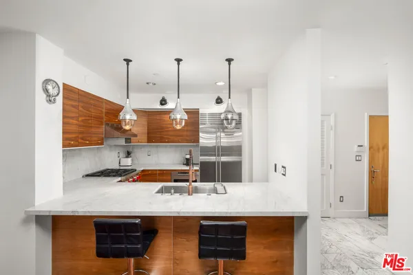 a kitchen with stainless steel appliances granite countertop a sink a stove and a wooden floor