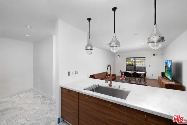a view of a room with kitchen island stainless steel appliances sink and living room view