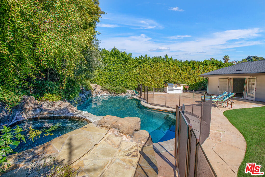 16636 Calneva Drive Encino, CA 91436 - Photo 1 of 19 a view of a patio with couches table and chairs under an umbrella