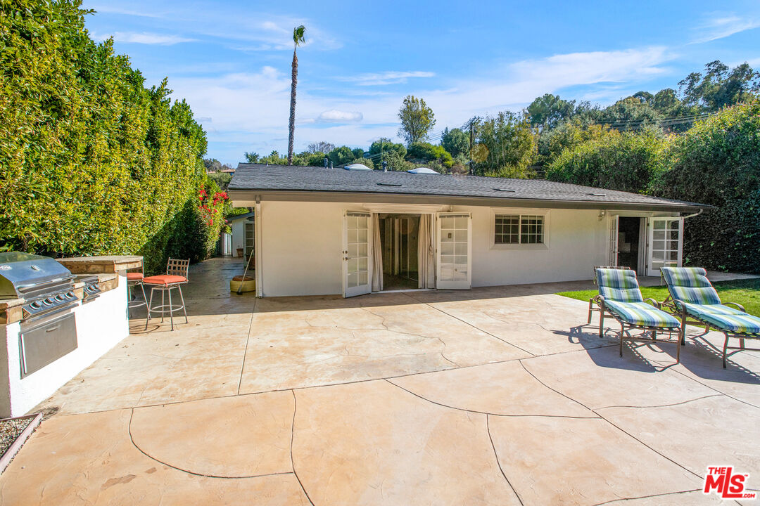 16636 Calneva Drive Encino, CA 91436 - Photo 18 of 19 a backyard of a house with yard and outdoor seating