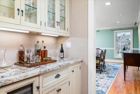 a kitchen with granite countertop a table chairs and a wooden floor