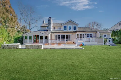a front view of a house with a garden and trees