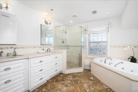 a bathroom with a tub sink and mirror