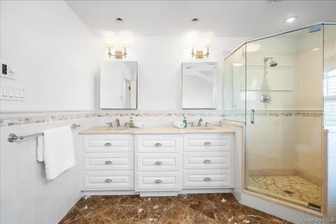 a bathroom with a granite countertop sink mirror and shower