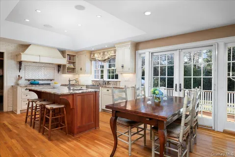 a dining room with stainless steel appliances a dining table and chairs