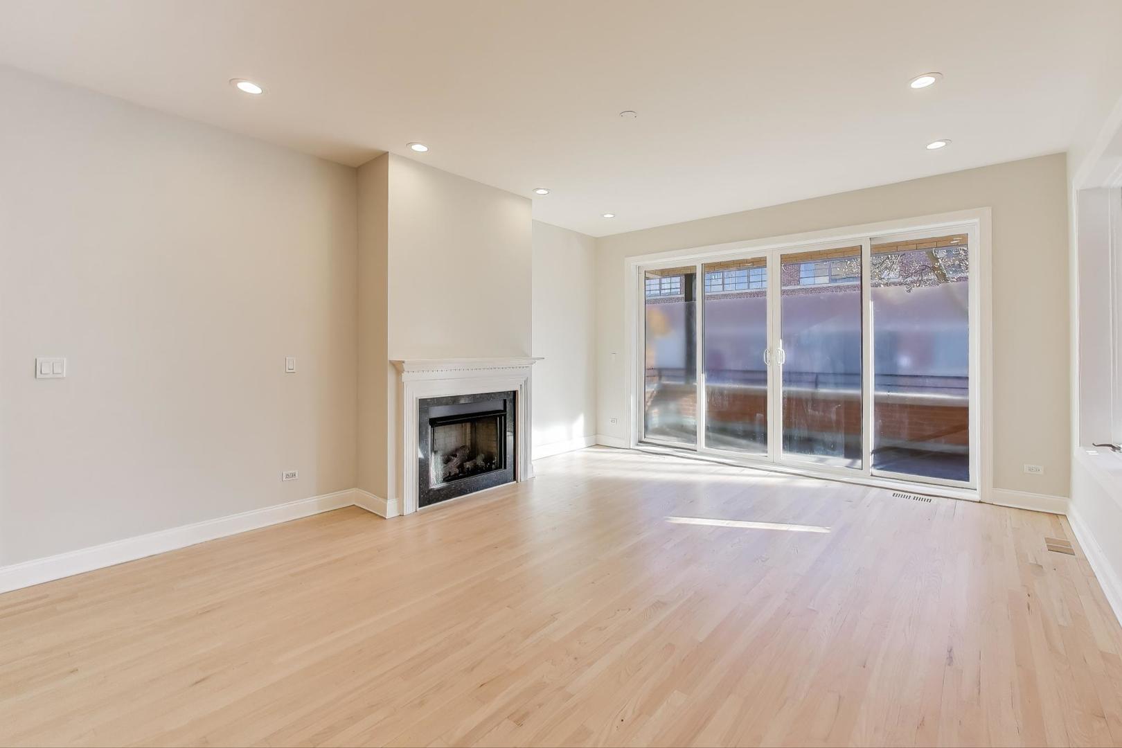 1920 North Springfield Avenue, Unit 1S Chicago, IL 60647 - Photo 9 of 36 an empty room with wooden floor and fireplace
