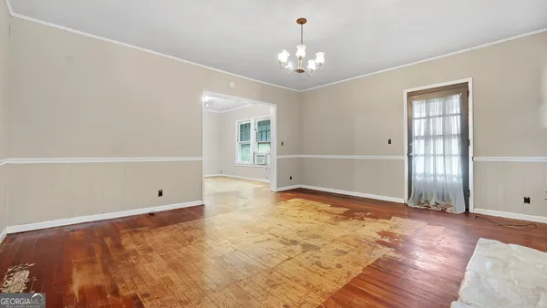 a view of an empty room with wooden floor fireplace and a window