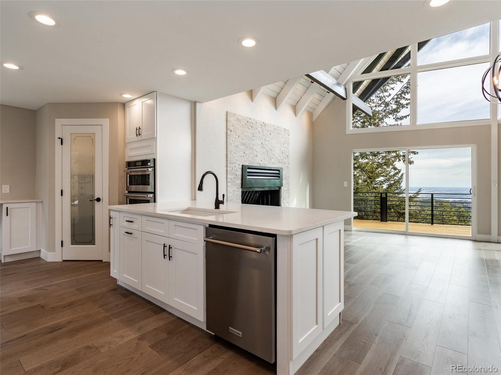 442 Deer Trail Road Boulder, CO 80302 - Photo 11 of 40 a large white kitchen with a large window a sink and stainless steel appliances