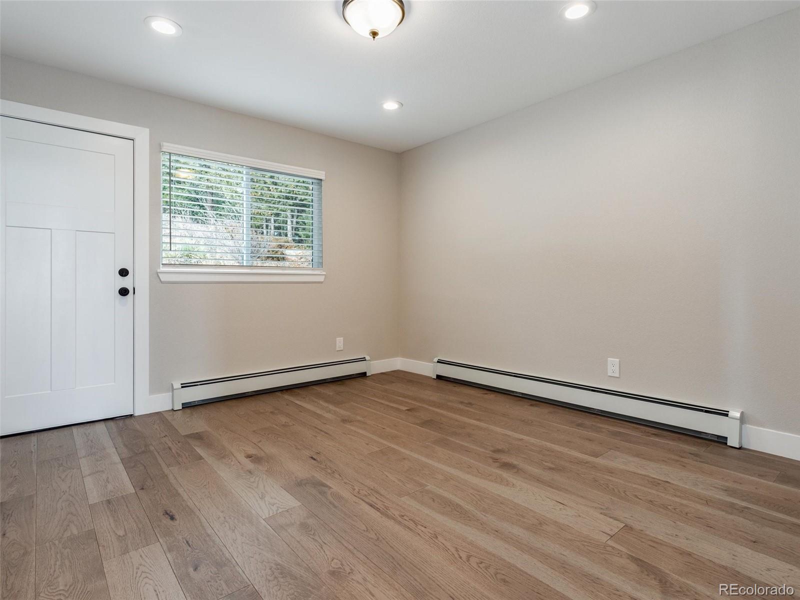 442 Deer Trail Road Boulder, CO 80302 - Photo 19 of 40 an empty room with wooden floor and windows