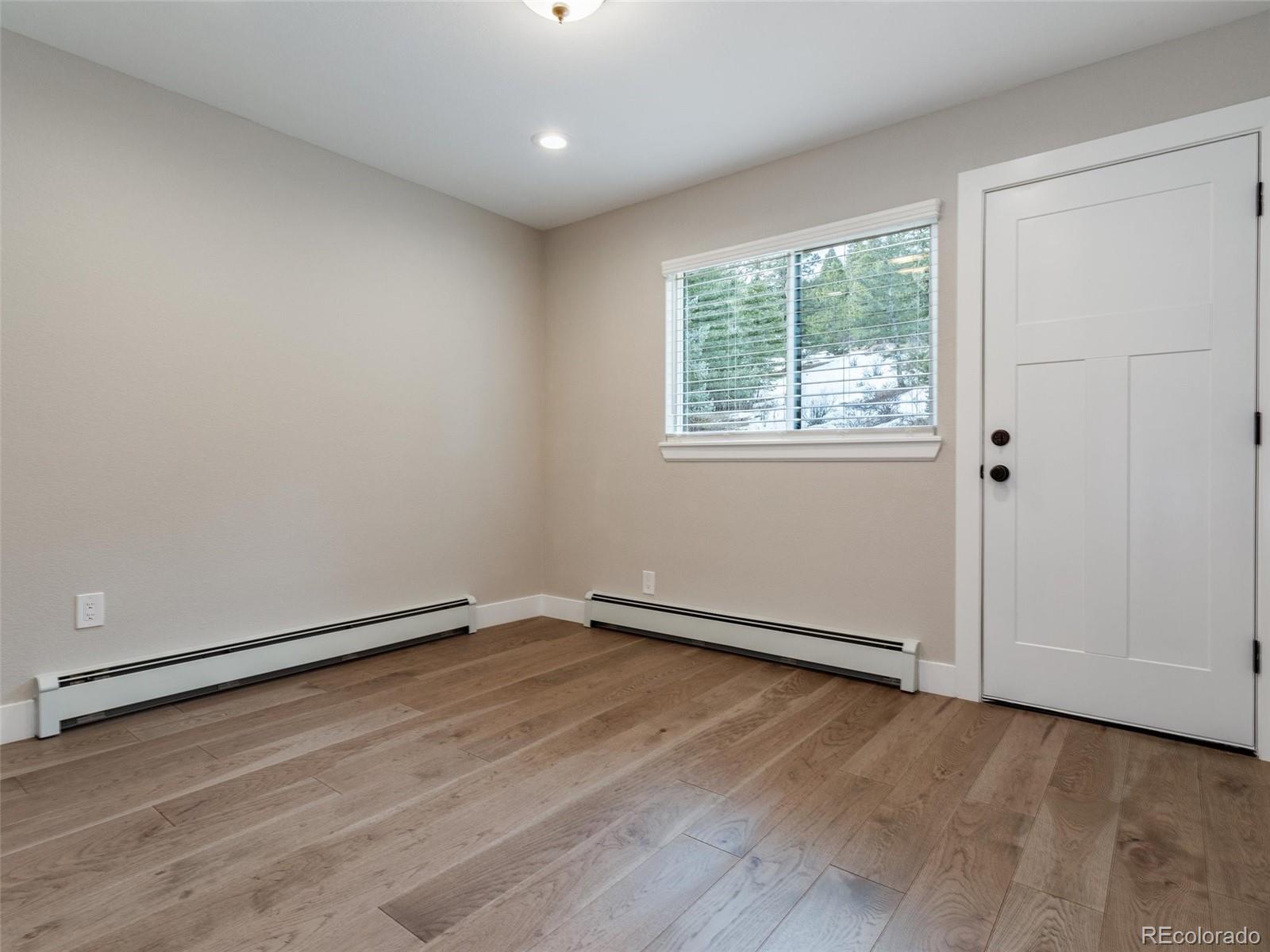 442 Deer Trail Road Boulder, CO 80302 - Photo 20 of 40 an empty room with wooden floor and windows