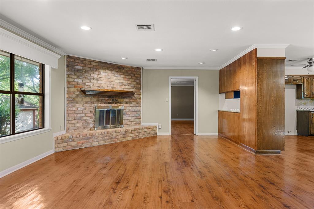 13539 Chapel Road Lorena, TX 76655 - Photo 7 of 37 Expansive living space featuring wood-finish flooring, a brick-faced fireplace with a hearth and mantel, recessed lighting, and a large window