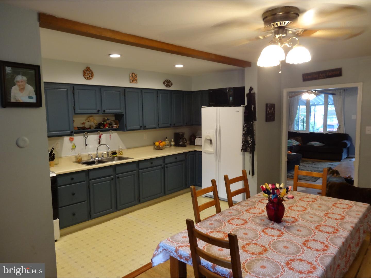 310 Ripka Street Philadelphia, PA 19128 - Photo 9 of 14 a kitchen with a refrigerator a stove a sink dishwasher with a dining table and chairs