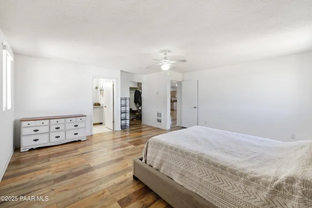 a spacious bedroom with a bed and a chandelier