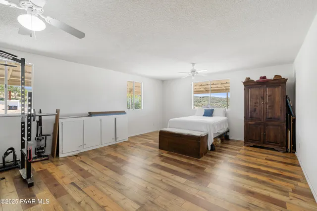 a spacious bedroom with a bed and a flat screen tv