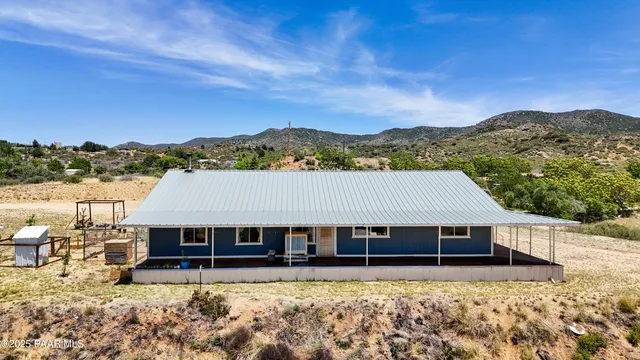 a view of a house with a yard and mountain in the background